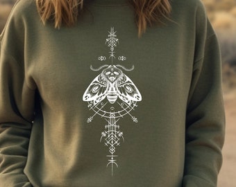 May include: A green sweatshirt with a white graphic of a moth with geometric designs. The moth is surrounded by a circle and other geometric shapes.