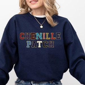 May include: A navy blue sweatshirt with the text "CHENILLE PATCH" in colorful embroidered letters.