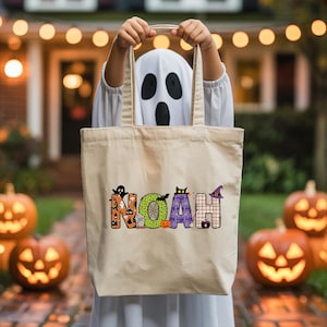 A person wearing a ghost costume holds a bag with the name "Noah" printed on it, standing in front of jack-o-lanterns.