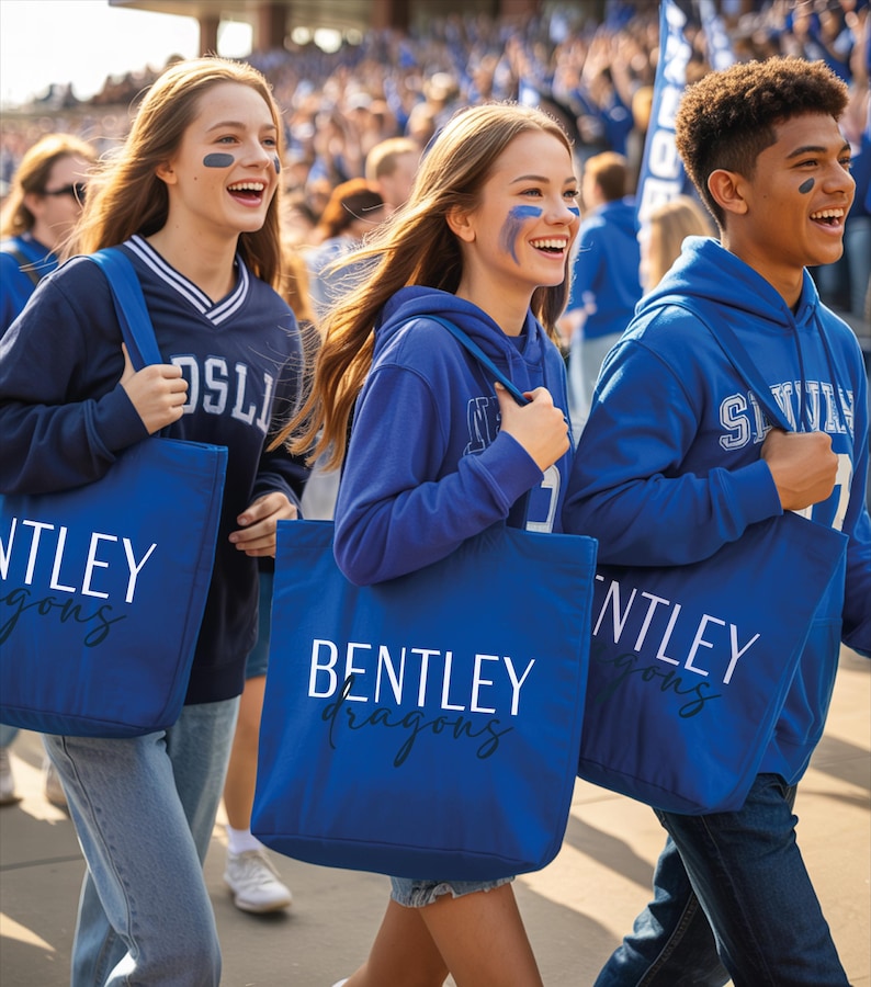 A group of people wearing blue shirts and carrying blue bags with the word "BENTLEY" printed on them, walking together in a crowd.