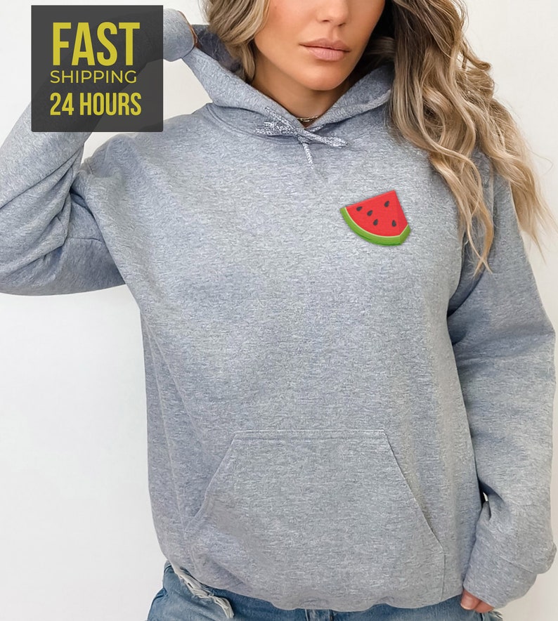 Op de afbeelding: Een grijs gem&ecirc;leerd hoodie met een klein watermeloen motief op de voorkant. De hoodie heeft een kangoeroezak en een capuchon met trekkoord.
