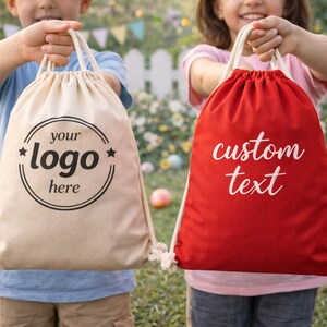 Two children holding bags with custom text printed on them, standing in front of a garden with Easter decorations.