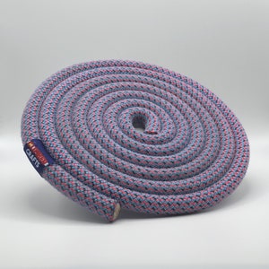 May include: A coiled length of blue and pink rope with a black woven pattern. The rope has a label that reads "Loopy Crafts".