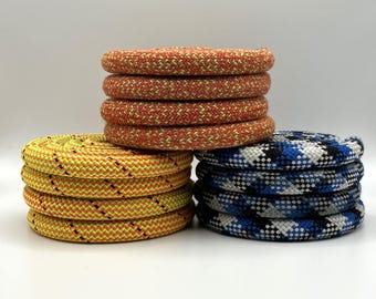 May include: Three stacks of colorful rope, one yellow and orange, one orange and yellow, and one blue, white, and black.