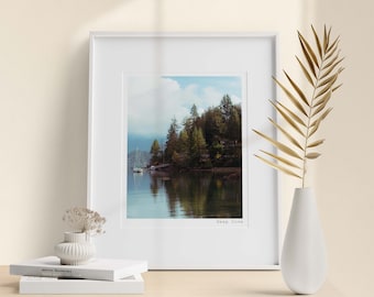 May include: A framed photograph of a lake with trees and a sailboat in the distance. The text "Deep Cove" is printed below the image.