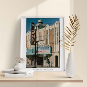 Könnte beinhalten: Ein Vintage-Foto des Stanley Theatre Company in Vancouver, British Columbia. Das Gebäude ist ein wunderschönes Beispiel für Art-Deco-Architektur mit einem großen Markisen-Schild, auf dem "Stanley" in Neonleuchten steht. Das Schild enthält auch den Text "Industrial Alliance Stage" und "Playbill".