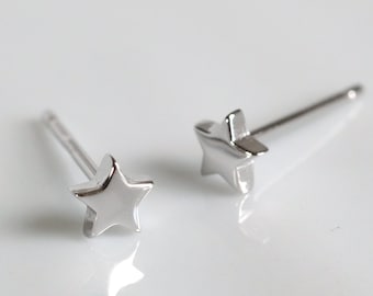 May include: A pair of silver star stud earrings. The earrings are small and delicate, with a simple star design.
