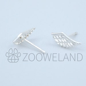 May include: A pair of silver wing-shaped stud earrings. The earrings feature feather-like detailing and a post for insertion. The image includes the text "ZOOWELAND" in grey.