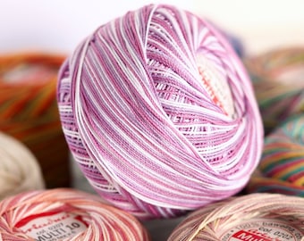 May include: Close-up of five balls of yarn in various colors, including pink and white stripes, orange and yellow stripes, white, and multi-colored stripes. The yarn balls have labels that say "Multi 10" and "Multi 1".