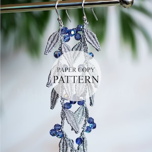 May include: Silver dangle earrings with blue crystal beads. The earrings are hanging from a silver rod. The text "PAPER COPY PATTERN" is visible in the image.