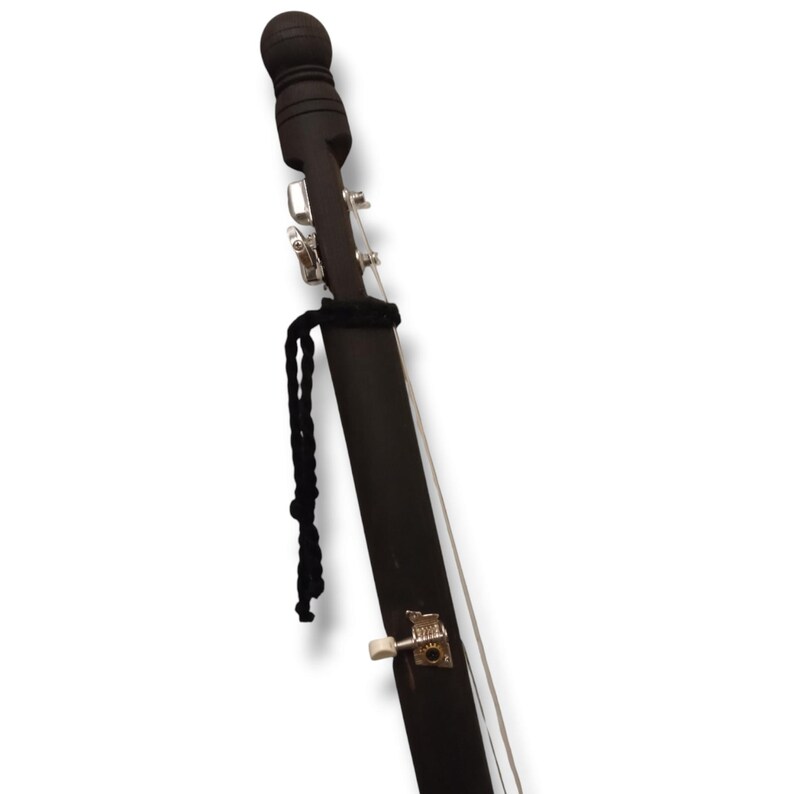 K&ouml;nnte beinhalten: Ein schwarzes Holzmusikinstrument mit einer schwarzen Schnur und einem silbernen Stimmwirbel. Das Instrument hat oben einen runden schwarzen Knopf.