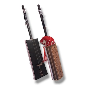 K&ouml;nnte beinhalten: Zwei traditionelle Saiteninstrumente mit Holzk&ouml;rpern und schwarz lackierten Oberfl&auml;chen. Die Instrumente haben einen langen Hals und eine einzelne Saite. Ein Instrument hat eine rote und wei&szlig;e gemusterte Stoffh&uuml;lle mit einem roten Quasten. Das andere Instrument hat eine schwarze und wei&szlig;e gefranste Stoffh&uuml;lle.