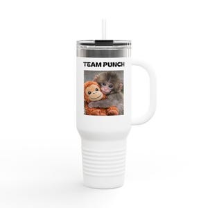 May include: White travel mug with a black lid and handle. The mug features the text "TEAM PUNCH" above an image of two monkeys hugging. One monkey is gray, and the other is an orange stuffed toy.