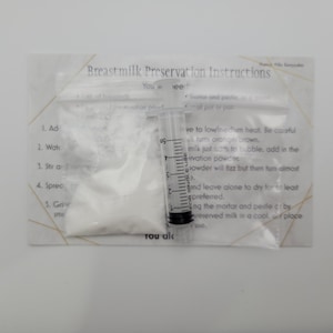 May include: A white powder in a clear plastic bag with instructions for breast milk preservation. The instructions include adding water, stirring, spreading, and grinding the powder with a mortar and pestle. A clear plastic syringe with a single-use label is also included.