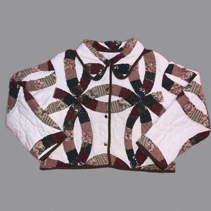 May include: A quilted jacket with a distinctive design. The jacket has a white base with a pattern of interlocking rings in burgundy, green, and tan. The collar and trim are a dark brown colour.