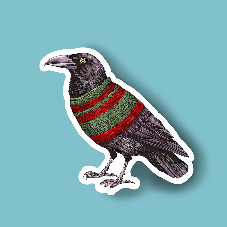 May include: A sticker featuring a detailed illustration of a black crow wearing a green and red striped sweater. The crow has a yellow eye and is set against a light blue background with a white border, creating a sticker effect. The artwork has a vintage, hand-drawn style.