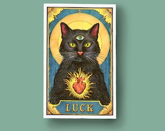 May include: A vintage-style tarot card illustration featuring a black cat with a third eye and a red heart in its chest. The card is surrounded by a gold frame and has the word "LUCK" printed on it.
