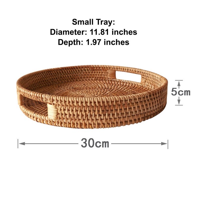 Op de afbeelding: Een ronde, geweven rotan dienblad met een diameter van 30 cm en een diepte van 5 cm. Het dienblad heeft twee ingebouwde handgrepen. De tekst op de afbeelding luidt "Small Tray".
