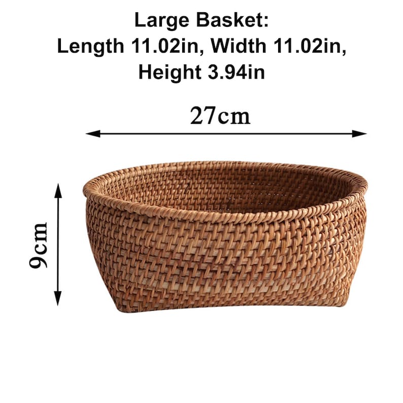 以下が含まれることがあります： 長さ27cm、幅27cm、高さ9cmの、編み込まれた茶色のバスケット。バスケットは丸みを帯びた形で、天然素材で作られています。画像には「Large Basket」と書かれています。