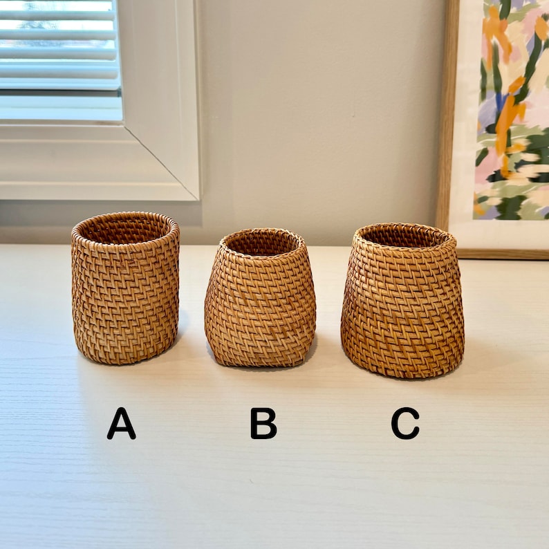 Pu&ograve; includere: Tre cesti in rattan intrecciato di diverse dimensioni. I cesti sono cilindrici con una base leggermente svasata. Il colore marrone naturale del rattan &egrave; visibile e il motivo di tessitura &egrave; ben definito. I cesti sono etichettati A, B e C.