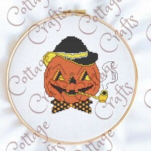 May include: A cross-stitch pattern of a smiling pumpkin wearing a black hat with a yellow band, a bow tie, and smoking a pipe.