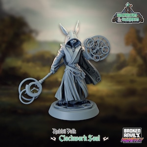 May include: A gray, 3D printed miniature of a rabbit-like creature wearing a hooded robe and holding a staff with clockwork gears. The figure is standing on a circular base with clockwork details. The text "Rabbit Folk Clockwork Soul" is printed below the base.