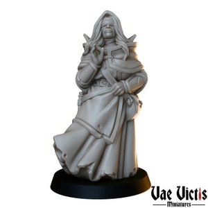 May include: A gray painted miniature figurine of a blindfolded person wearing a long robe and holding their hands together in prayer. The figurine is standing on a black base.