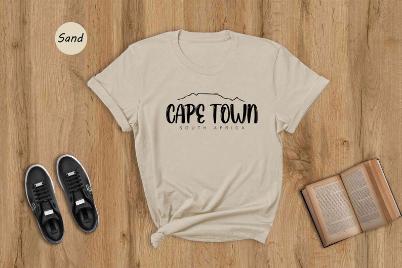 a t - shirt that says cape town on it next to a pair of shoes