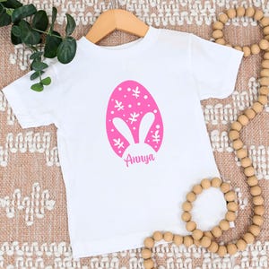 a white shirt with a pink bunny ears on it