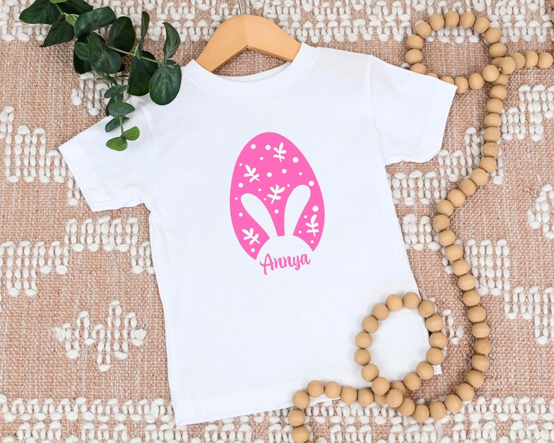 a white shirt with a pink bunny ears on it