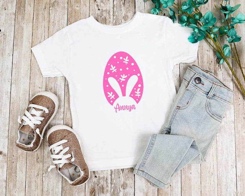 a t - shirt with an easter egg on it next to a pair of jeans