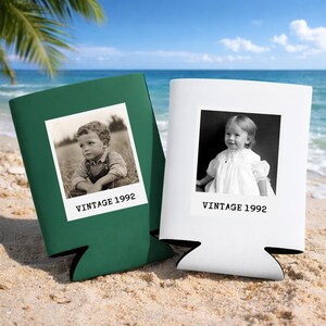 Two vintage-style photo frames, one green and one white, are placed on a sandy beach with palm trees in the background.