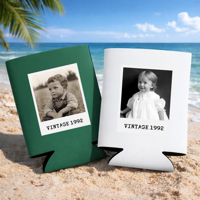 Two vintage-style photo frames, one green and one white, are placed on a sandy beach with palm trees in the background.