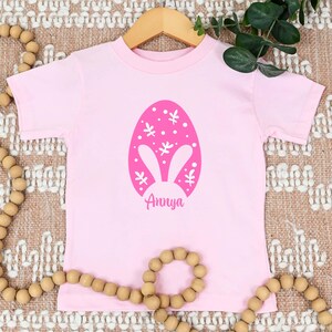 a pink t - shirt with an easter egg on it