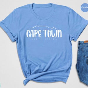 a blue shirt that says cape town next to a pair of blue shoes