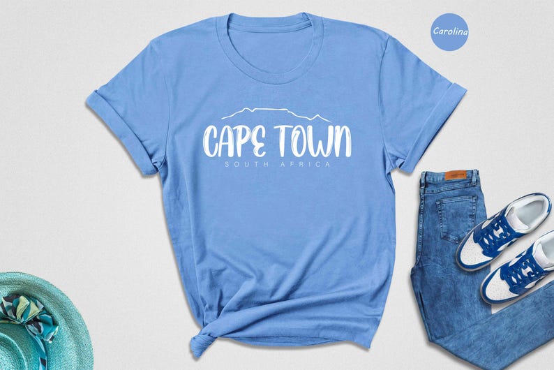 a blue shirt that says cape town next to a pair of blue shoes