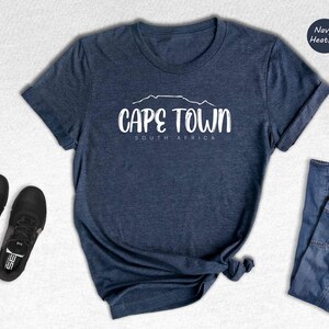 a t - shirt that says cape town next to a pair of jeans