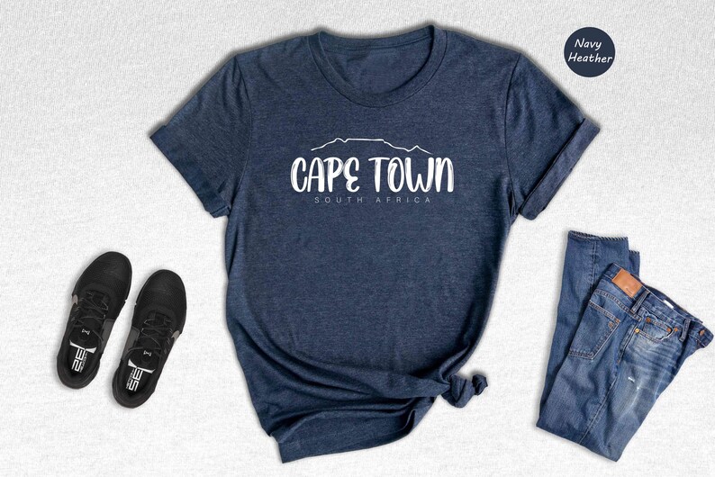 a t - shirt that says cape town next to a pair of jeans