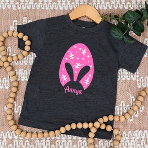 a black shirt with a pink bunny face on it