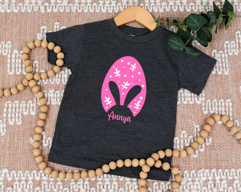 a black shirt with a pink bunny face on it