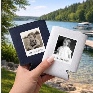 A hand holding two vintage photo holders with black and white photographs of young children, set against a scenic background of a lake and trees.