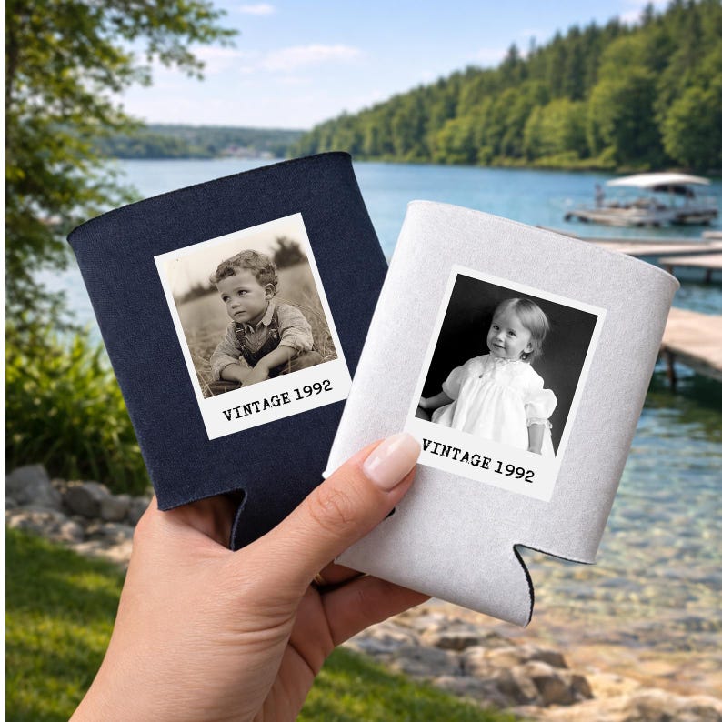 A hand holding two vintage photo holders with black and white photographs of young children, set against a scenic background of a lake and trees.