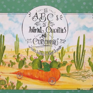 May include: A book cover with a green background and white polka dots. The title is "The ABC's of Animal Oddities and Curiosities" written in black cursive. The cover features a cartoon illustration of a green lizard riding in a carrot.