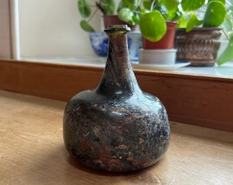 Early glass spirit or wine bottle, England antique before 1600 Medieval in heavy &#39;onion&#39; form with tapering neck and marbled effect H14cm