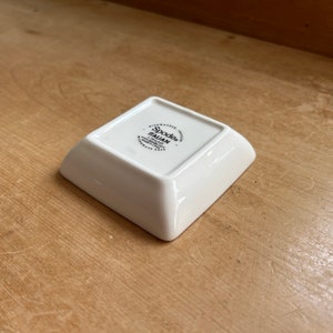 May include: White square ceramic dish with a black Spode Italian logo on the bottom. The logo includes the website address and the words "Dishwasher Safe".