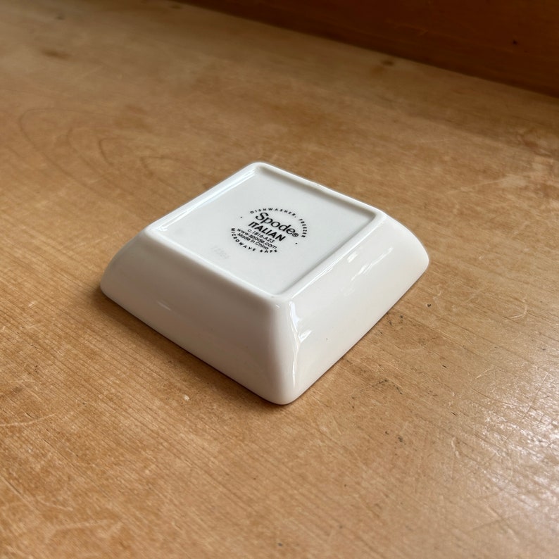 May include: White square ceramic dish with a black Spode Italian logo on the bottom. The logo includes the website address and the words "Dishwasher Safe".