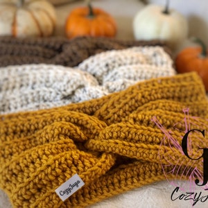 May include: Three crocheted headbands in brown, cream, and mustard yellow. The headbands are made with a twisted stitch and have a label that says "Cozy Juga".