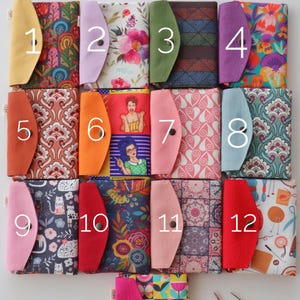 May include: Twelve colorful fabric pouches with different patterns and designs. Each pouch has a number from 1 to 12 printed on the front. The pouches are arranged in four rows of three.