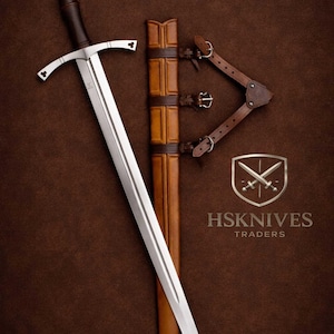May include: A long, silver sword with a brown handle and crossguard, resting beside a brown leather sheath and straps. The image includes the text "HSKNIVES TRADERS" on a shield logo, set against a brown background.