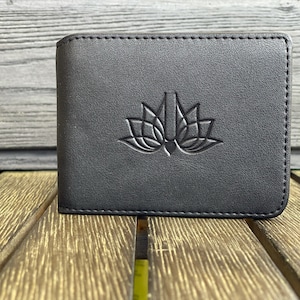 May include: A black leather wallet with a stitched edge and a lotus flower design embossed on the front.